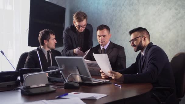 Mensen uit het bedrijfsleven hebben een vergadering conferentie over toekomstig succes van het bedrijf. moderne stad kantoor interieur, groep vier business man aan het werk op laptop op vergadering samen op kamer — Stockvideo