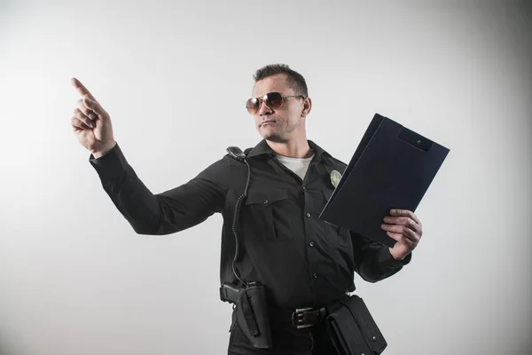 Um homem vestido com um traje de polícia EUA, dedo aponta — Fotografia de Stock