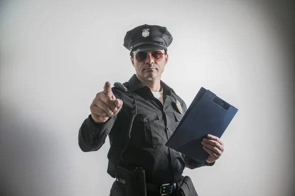 Um homem vestido com um traje de polícia EUA, dedo aponta — Fotografia de Stock