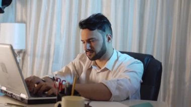 ofiste oturan ve laptop ile çalışan genç işadamı 