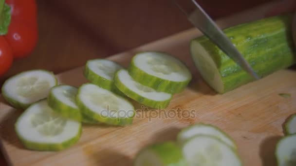 Händerna på kocken skär gurkan med en kniv — Stockvideo