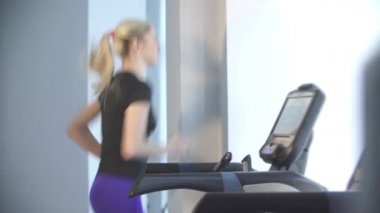 güzel genç kız spor ve fitness devreye girer, o simülatörü koşu bandı üzerinde çalışan