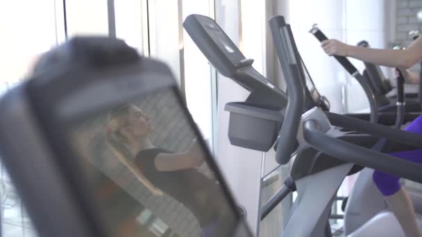 Schöne junge Mädchen ist in Sport und Fitness engagiert, läuft sie auf dem Simulator Laufband — Stockvideo