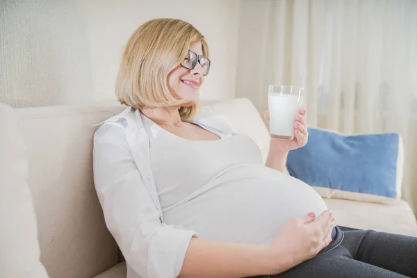 pregnant woman drinking milk at home