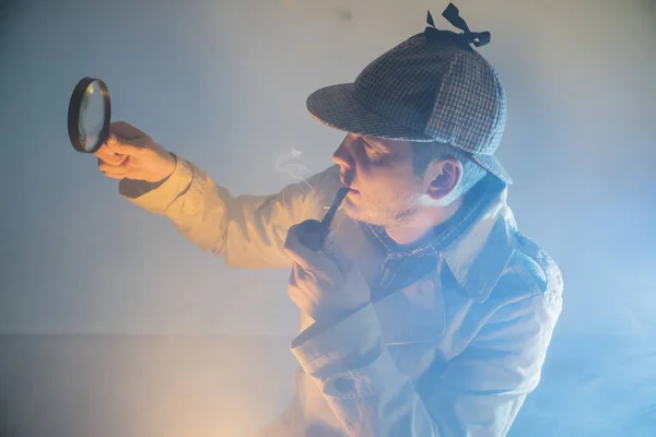 sherlock holmes in studio detective at work with magnifying glass and pipe