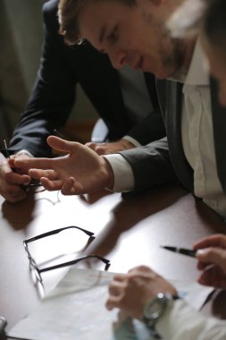 Yeni proje tartışıyor masada oturan üç iş adamları