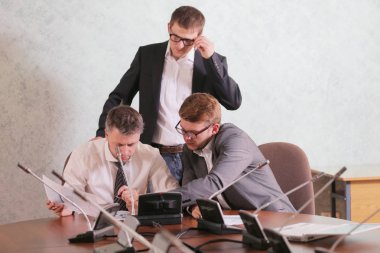 Üç işadamları birlikte modern ofis yeni proje üzerinde