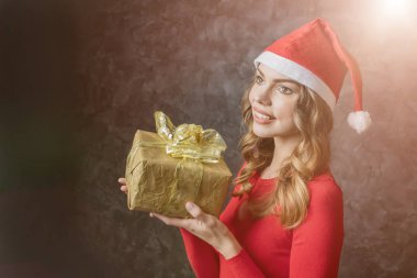 Noel şapkalı güzel kız elinde bir kutu hediyeyle