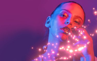 Model metalik gümüş dudaklar ve neon mavisi ve mor renkli yüzlü kadın, stüdyoda poz veriyor, güzel kız, parıldayan makyaj, renkli.