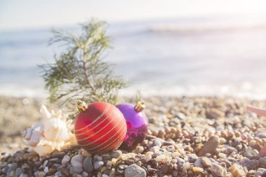 Plajdaki tropik tatil beldesinin sahilinde Noel oyuncakları. Yeni yıl ve Noel kartları için kavram kullanılabilir