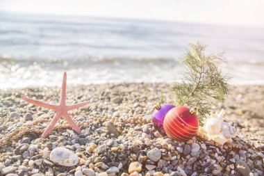 Plajdaki tropik tatil beldesinin sahilinde Noel oyuncakları. Yeni yıl ve Noel kartları için kavram kullanılabilir
