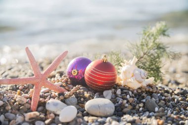 Plajdaki tropik tatil beldesinin sahilinde Noel oyuncakları. Yeni yıl ve Noel kartları için kavram kullanılabilir