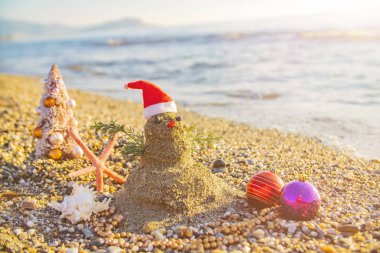 Kar yerine kumdan yapılmış tatillerde kardan adam. Yeni yıl ve Noel kartları için konsept tatil beldesi kullanılabilir