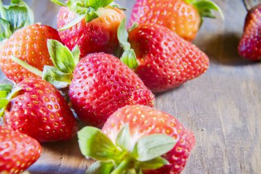 Çilek, ahşap arka planda kapanıyor.