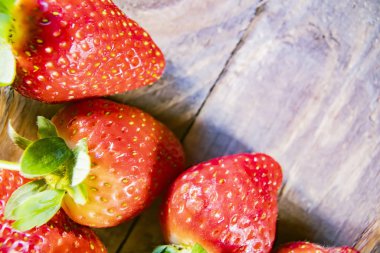 Çilek, ahşap arka planda kapanıyor.