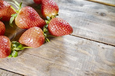 Çilek, ahşap arka planda kapanıyor.
