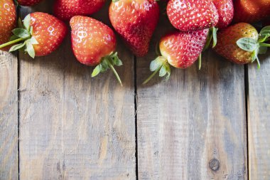 Çilek, ahşap arka planda kapanıyor.