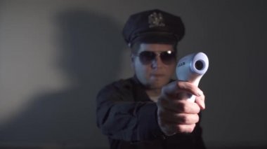Polis kıyafetli bir adam sıcaklığı uzaktan kontrol ediyor, el kamerasında kızılötesi termometre var, ısı algılaması,