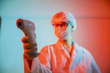 Kadın doktor termometre ve korona virüsü konseptini kontrol ediyor.