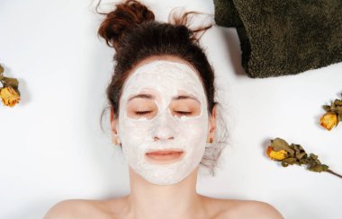 Güzel kadın gözleri kapalı ve Beyaz kil maskesi ile. Spa cilt ve vücut bakımı. Yüz güzellik bakımı.