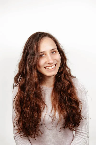 Retrato alegre de una mujer feliz sonriente con el pelo largo y rizado mirando a la cámara sobre fondo blanco . — Foto de Stock