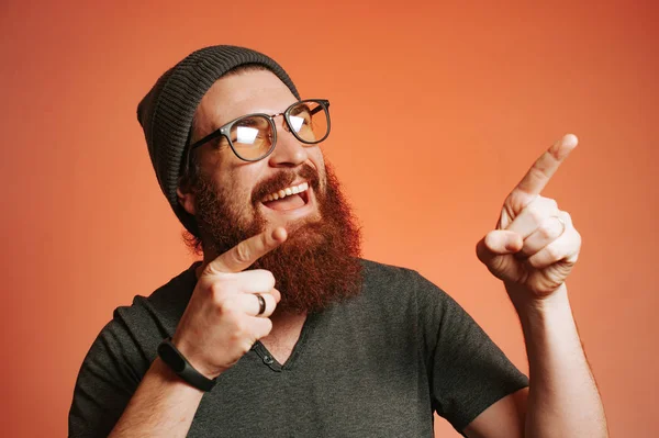 Hombre hipster barbudo con gafas apuntando —  Fotos de Stock