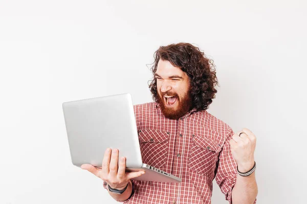 Heureux homme excité tenant ordinateur portable et levant le bras — Photo