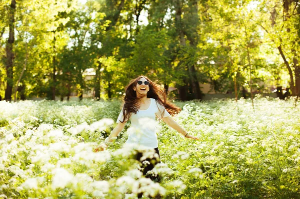 Młoda kobieta wesoły, bieganie i skakanie w kwiat pole odkryty — Zdjęcie stockowe