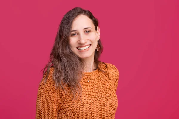 Retrato de una joven alegre sonriendo y mirando con confianza a la cámara sobre un fondo rosado — Foto de Stock