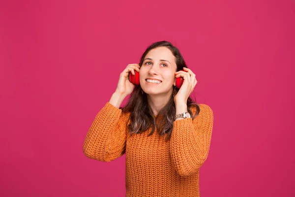 Retrato de mulher jovem ouvindo música em fones de ouvido sem fio — Fotografia de Stock