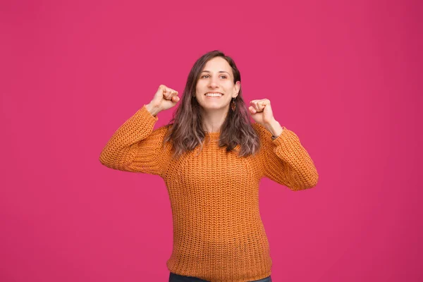 Joven alegre en suéter celebrar el éxito sobre fondo rosa — Foto de Stock