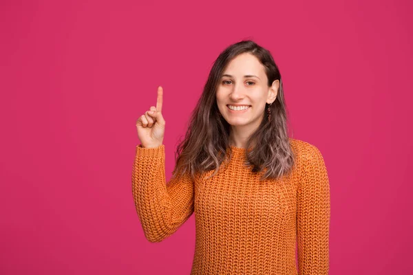 Retrato de mujer sonriente en sweeater apuntando hacia arriba en el copyspace — Foto de Stock