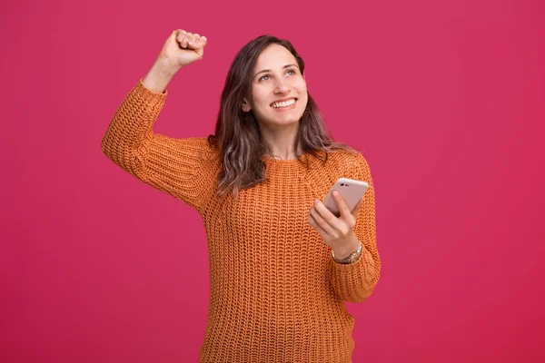 Foto de mulher bonita jovem espantada comemorar o sucesso e segurando smartphone — Fotografia de Stock