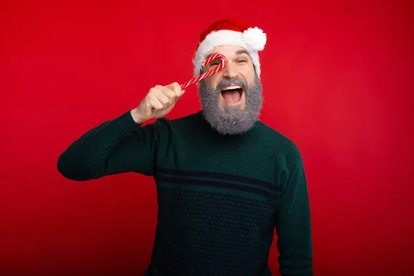 Cheerful hipster man with white beard holding red xmas candy — Φωτογραφία Αρχείου