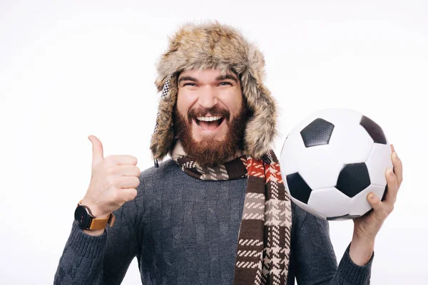 Glada skäggiga hipster man håller fotboll och visar tummen upp — Stockfoto