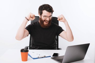 Vman yumruklarıyla kutluyor ve dizüstü bilgisayarına bakıyor.