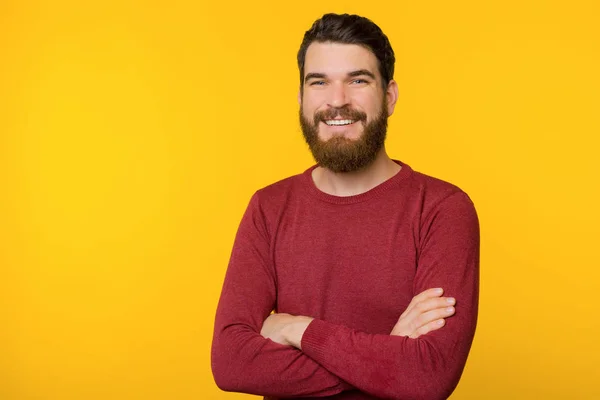 Foto di ragazzo barbuto, in piedi con le braccia incrociate, guardando e sm — Foto Stock