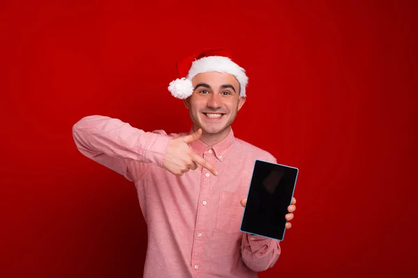 Χαρούμενος έκπληκτος άνθρωπος στέκεται πάνω από το κόκκινο φόντο και δείχνοντας ένα — Φωτογραφία Αρχείου
