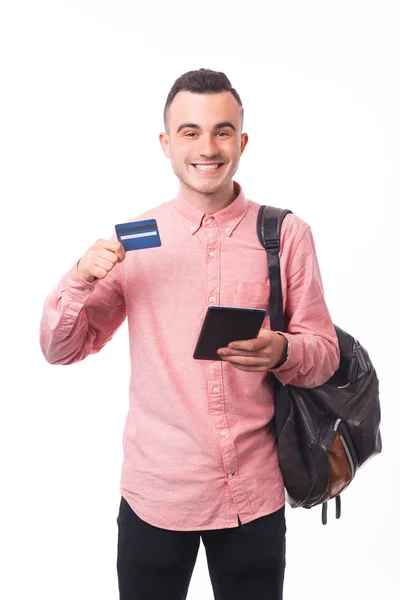 Veselý mladý student, drží tablet a ukazuje kreditní kartu — Stock fotografie