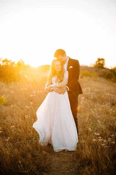 Una giovane coppia felice festeggia il suo amore in mezzo al campo . — Foto Stock