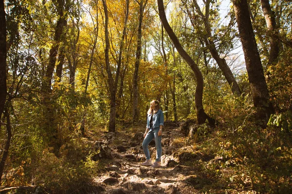 Una joven está de pie en medio del bosque . —  Fotos de Stock