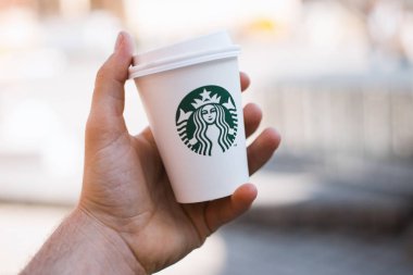 Romanya / Brasov - 16 / Eylül / 2019 Fotoğraf: Starbucks marka kahve tutan bir adam 