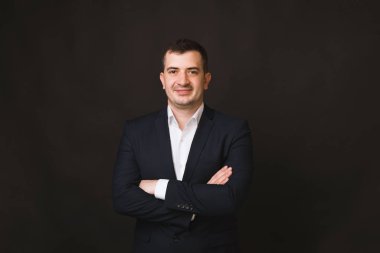 İş adamı portresi, resmi kıyafetler içinde, kameraya bakıyor.