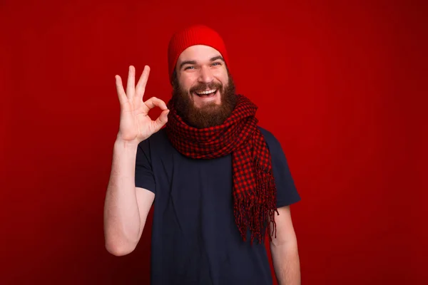 Весела бородата матуся, в червоному капелюсі і шарфі, показує добре знак — стокове фото