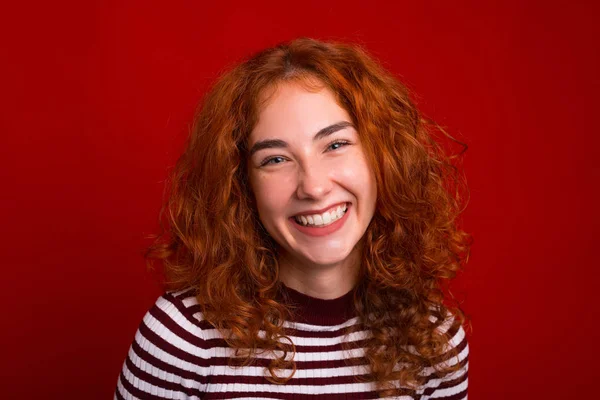 Retrato de niña feliz, con el diente sonriendo sobre el fondo rojo — Foto de Stock
