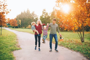 Genç bir aile parkta yürürken eğleniyor..