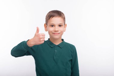 Neşeli gülümseyen küçük çocuk beyaz arka planda duruyor ve...