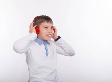 Kablosuz kırmızı kulaklık takan genç mutlu çocuğun fotoğrafı.