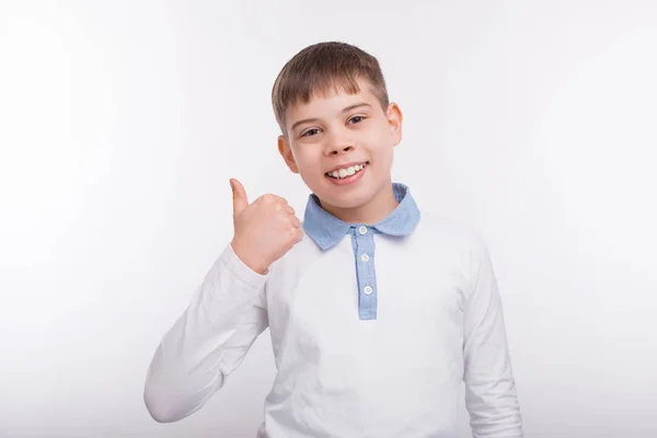 Jovem menino feliz mostrando polegares para cima sobre fundo branco — Fotografia de Stock