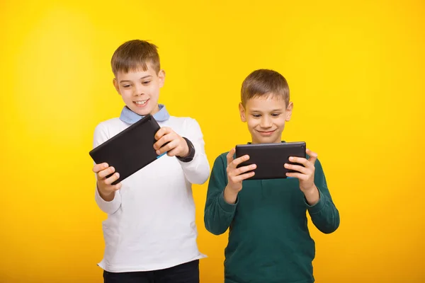 Два мальчика играют в игры на планшете — стоковое фото